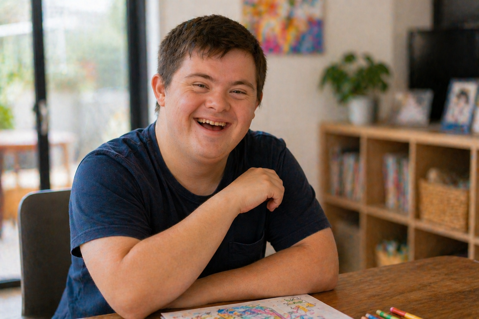 A behaviour support practitioner sharing a creative drawing activity with a young child at a table